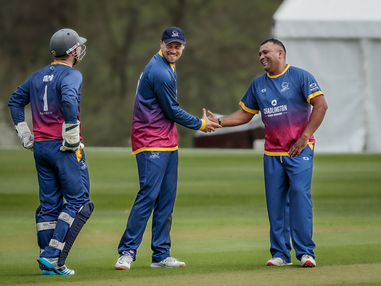 Oxfordshire's Samit Patel is congratulated by Harrison Ward and Jonny Cater after taking three wickets in an over in the second of two NCCA T20 matches against Buckinghamshire played at Wormsley Cricket Ground on April 16th, 2023.