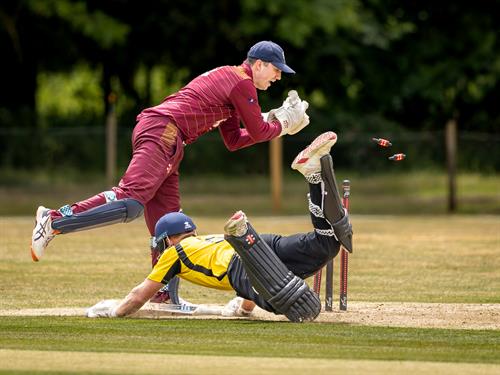 Hertfordshire's Ben Clifford survives a near run-out as Suffolk's Jacob Marston breaks the wicket in the first of two NCCA Dojo T20 matches at Mellis Cricket Club on July 5th, 2026.